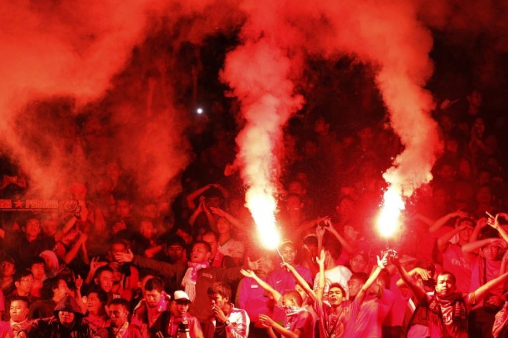 Supporters light flares at a match in March. No political party can draw such a big, devoted crowd, a soccer official says. Photo: Reuters