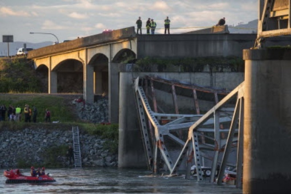 A portion of the Interstate 5 bridge is submerged after it collapsed into the Skagit River dumping vehicles and people into the water as rescuers watch from the collapsed section of Interstate 5 and hovercraft search for survivors below in Mount Vernon, Washington. Photo: AP