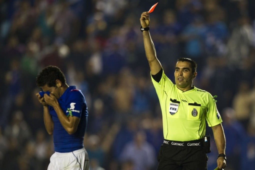 Referee shows the red card. Photo: AFP