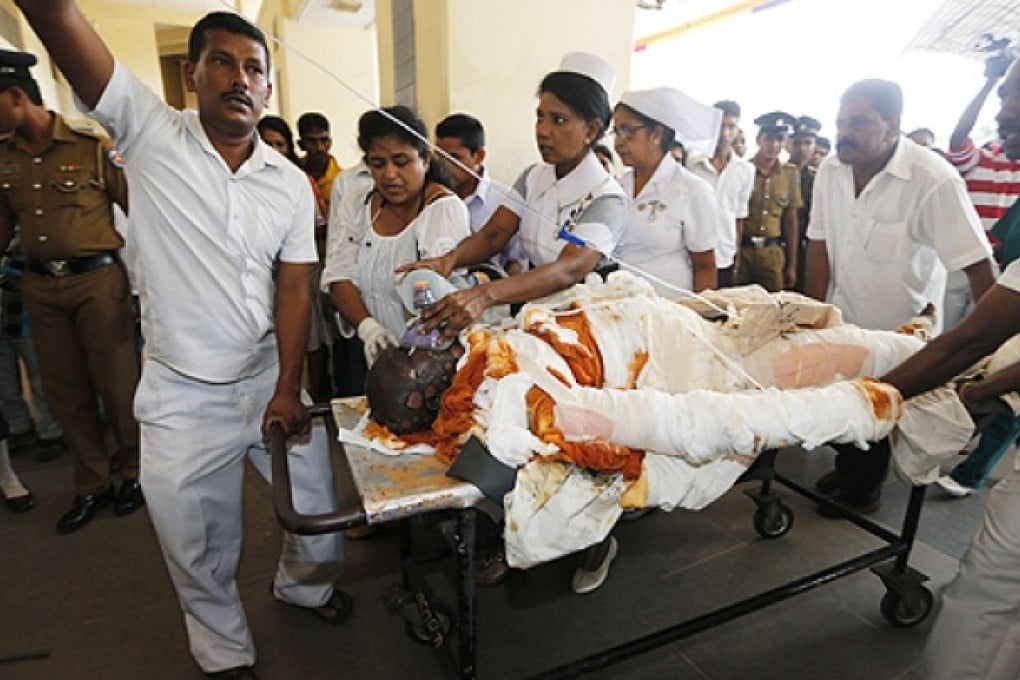 Sri Lankan hospital workers carry a Buddhist monk, identified as Bowatte Indrarathane, on a stretcher for treatment in Colombo, Sri Lanka, on Friday. Photo: AP