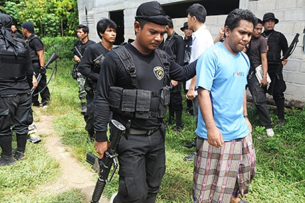 Suspected muslim militants are escorted by Thai police and soldiers after being arrested in Thailand's restive southern province of Narathiwat on Friday. Photo: AFP