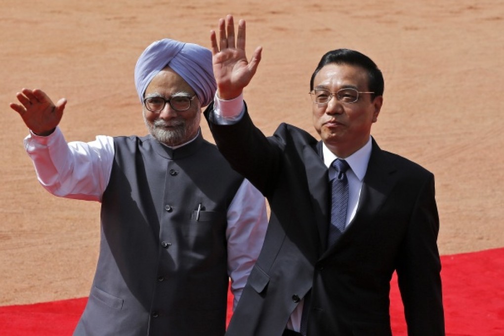 Chinese Premier Li Keqiang (right) and India's Prime Minister Manmohan Singh wave towards the media in New Delhi. Photo: Reuters
