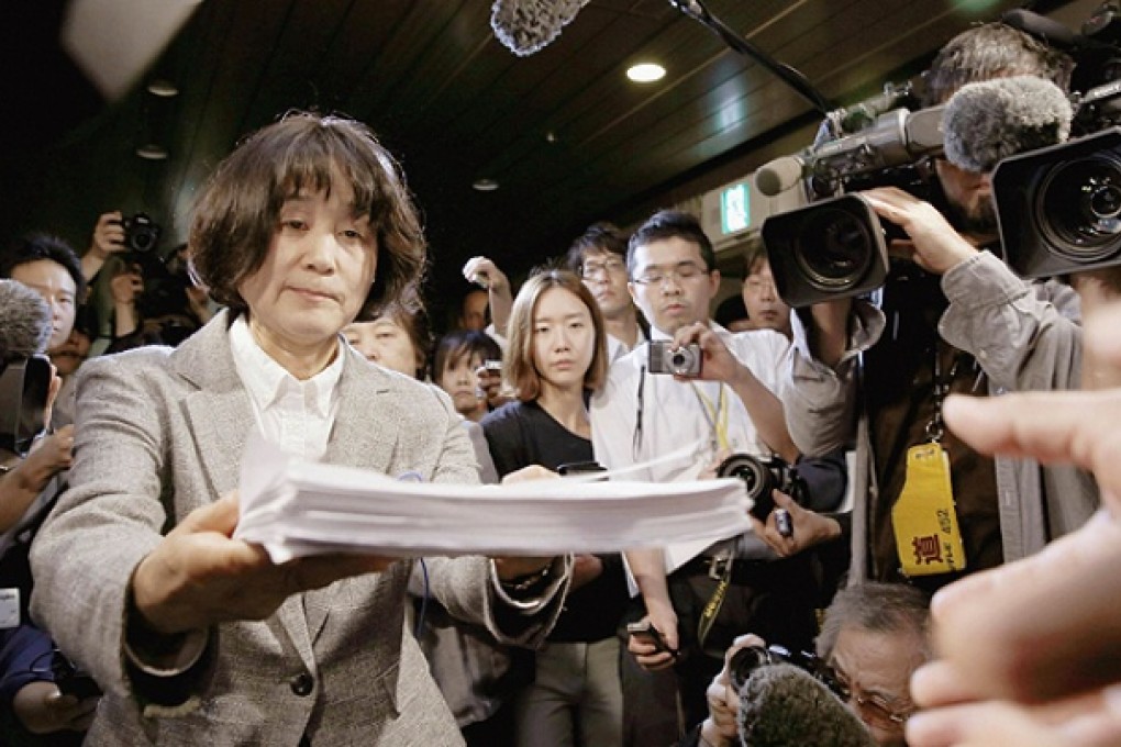Bang Chung-Ja, co-chair of the Korean Council for Women Drafted for Military Sexual Slavery, hands over a protest petition to an Osaka City Hall official. Photo: Reuters