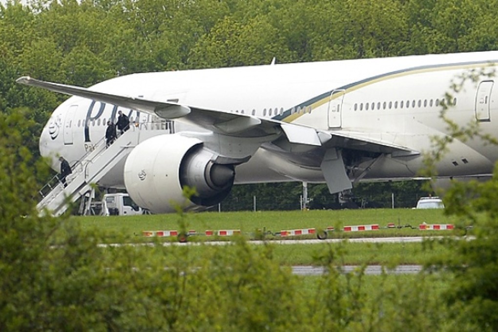 Police officers leave a Pakistan International Airlines Boeing 777 aircraft on the tarmac at Stansted Airport, England. Photo: Reuters