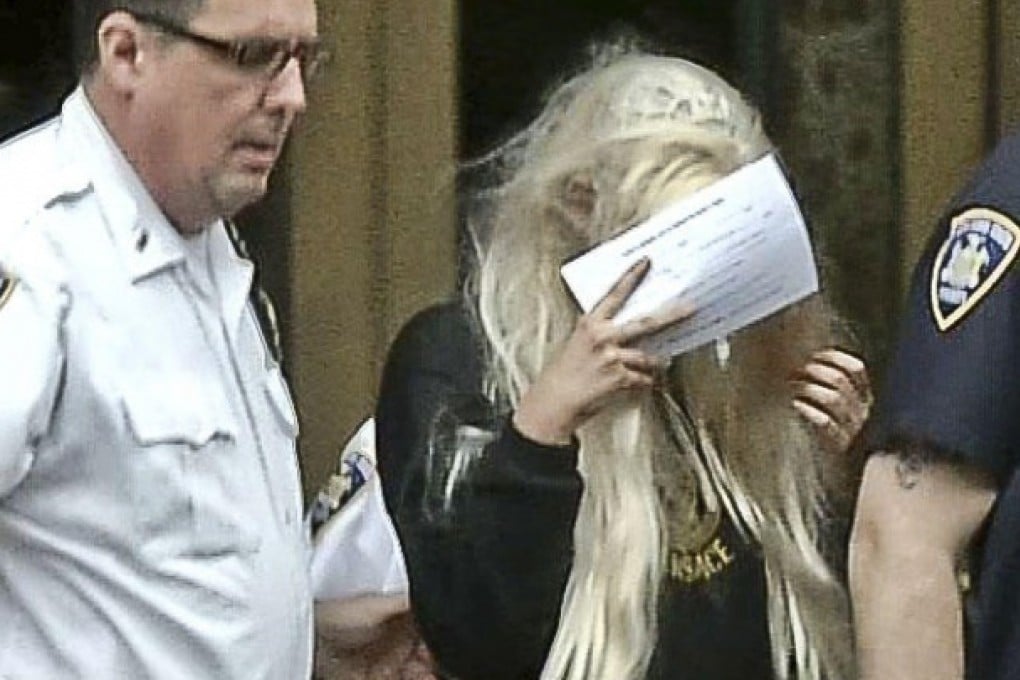 Amanda Bynes hides her face as she is led from court. Photo: AP