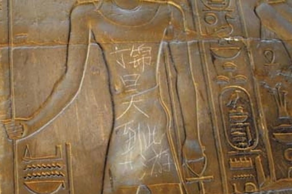 Graffiti reading 'Ding Jinhao was here' lies scratched into a piece of Egyptian artwork in the 3,500-year-old Temple of Luxor in Cairo.