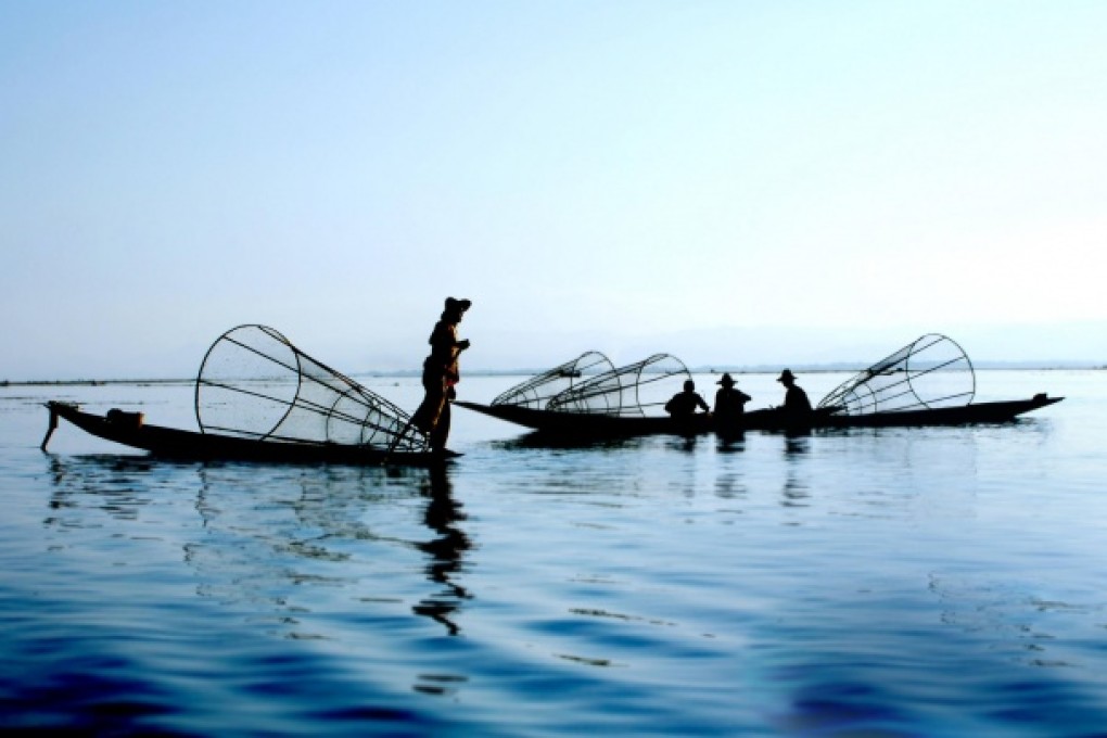 Fishermen set conical traps as they row their boats with their legs on Inle Lake, in Myanmar's Shan State. Photo: Thinkstock