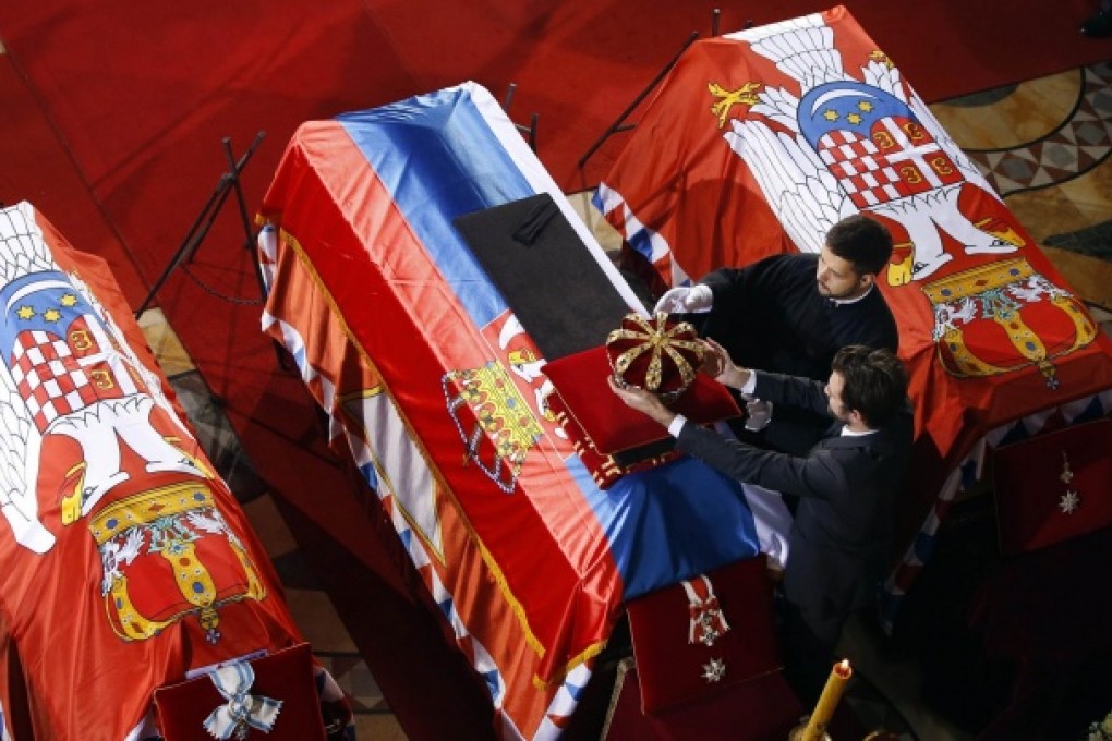 Prince Peter Karadjordjevic places the crown on the coffin of his grandfather inside St George's Church on Oplenac Hill, Serbia. Photo: Reuters
