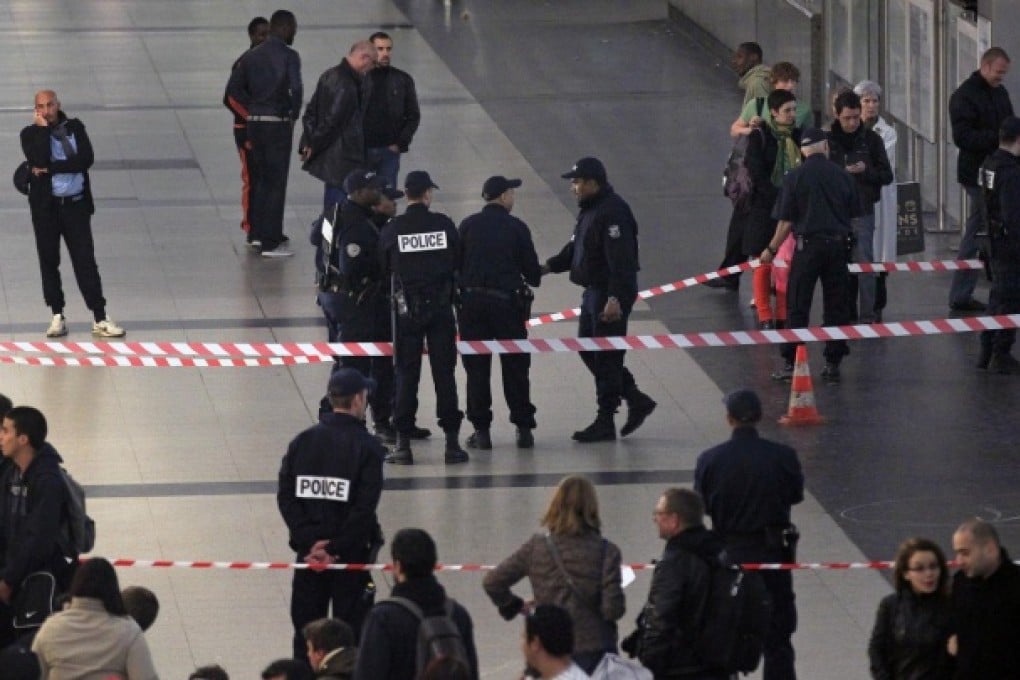 Police officers stand near the cordoned-off spot where a French soldier was stabbed in the throat in the busy commercial district of La Defense, just outside Paris. Photo: AP
