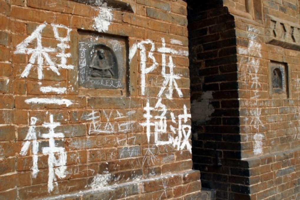 Graffiti covers a 1,400-year old pagoda at the Qinming Temple in Henan province. Photo: China Foto Press