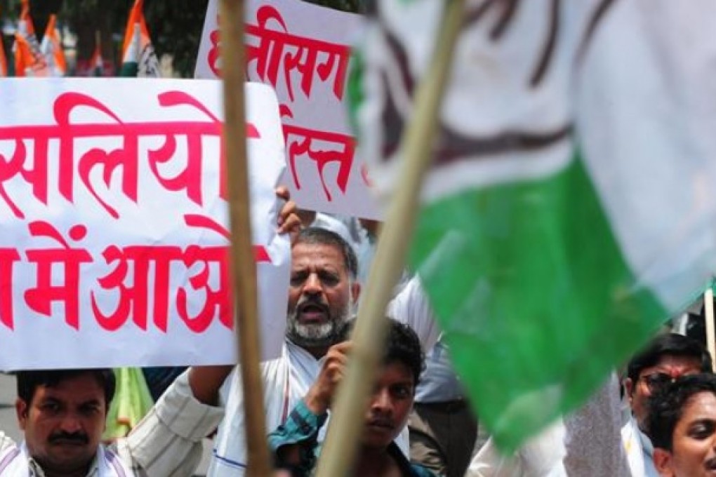 Congress party activists shout slogans and wave placards in Allahabad yesterday in a show of solidarity after the deadly attack on their fellow members on Saturday. Photo: AFP