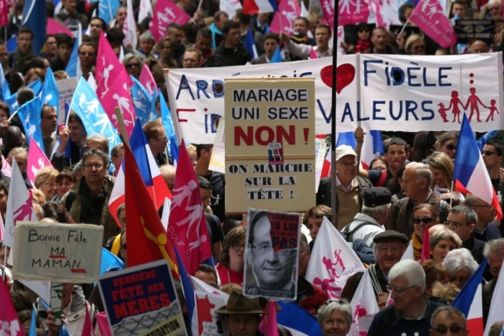 A demonstrator holds a placard with a portrait of French President Francois Hollande during the protest march in Paris. Photo: AFP
