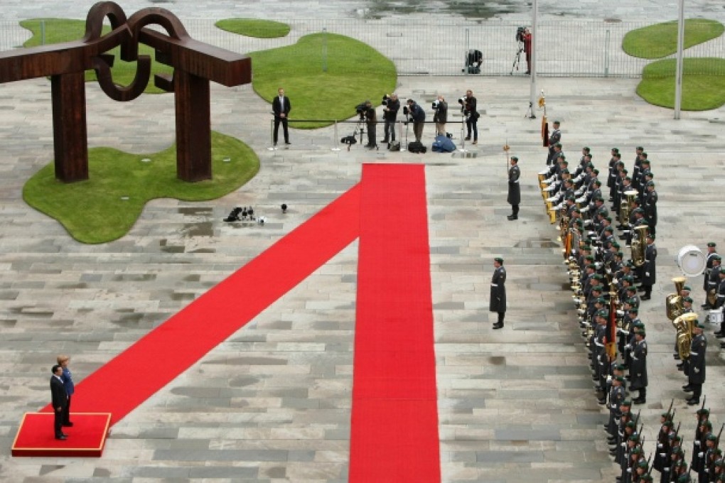 Li Keqiang and German Chancellor Angela Merkel review a guard of honour at the German federal Chancellery in Berlin on May 26, 2013. Photo: AFP