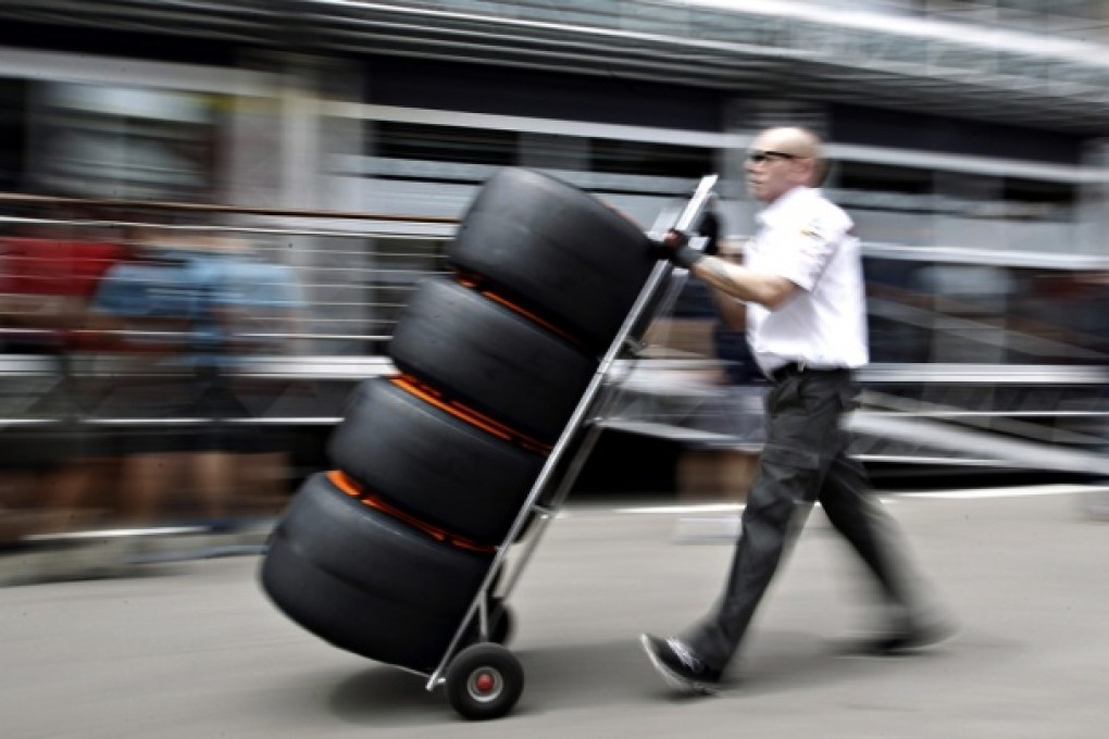 A mechanic pushes a trolley of Pirellis tyres. Photo: Reuters