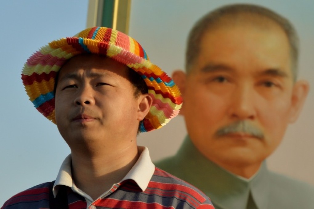 A Chinese tourist poses in front of a portrait of Sun Yat-sen at Tiananmen Square in Beijing. Photo: AFP