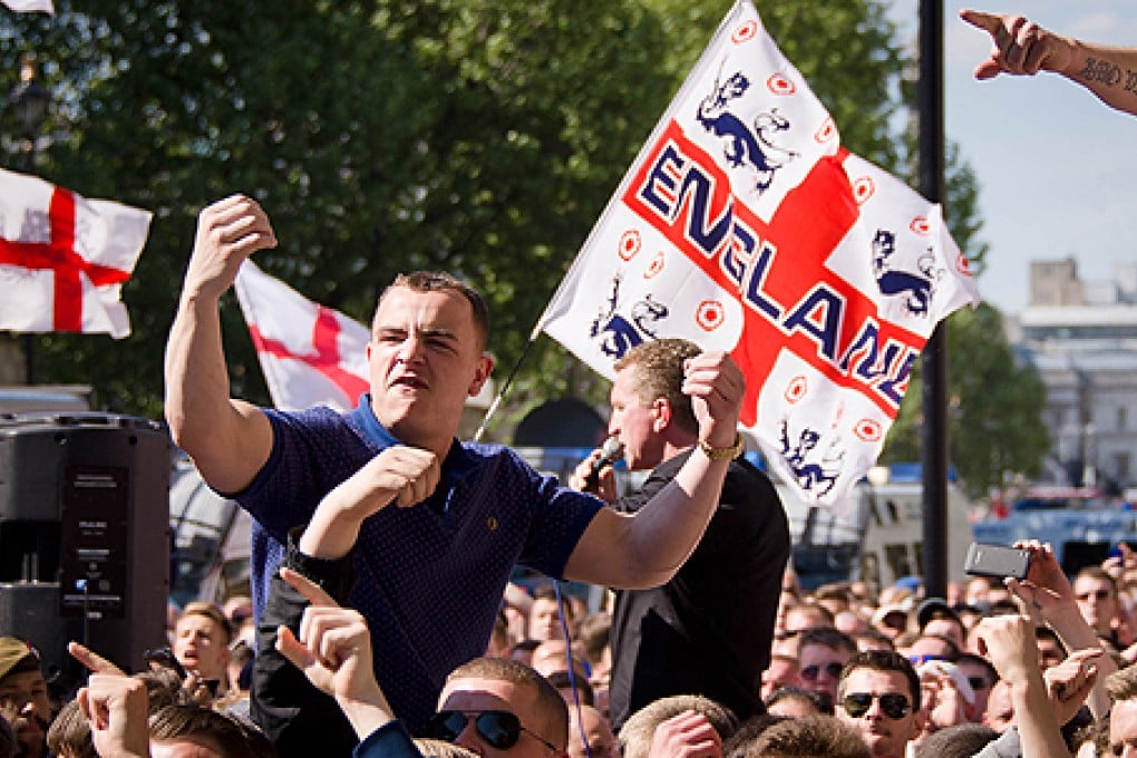 A supporter of the far-right English Defence League (EDL) gestures near Downing Street during a protest. Photo: AFP