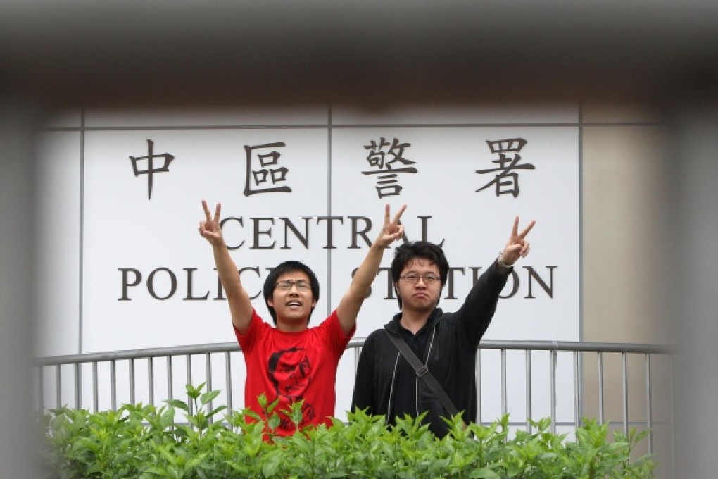 Two assistants of lawmaker Leung Kwok-hung, Raphael Wong and Anson Wong, make the victory sign after their arrests. Photo: David Wong