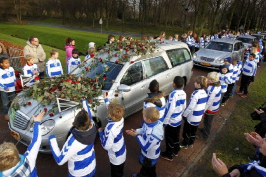 Members of Dutch soccer club SC Buitenboys lay roses on the hearse carrying the body of Richard Nieuwenhuizen at a crematory in Almere, Netherlands, on December 10 2012. Photo: Reuters