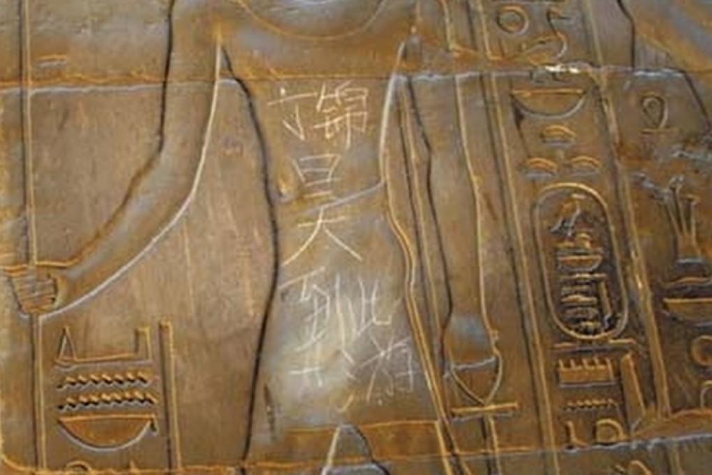 A 15-year-old boy named Ding Jinhao scrawl on a 3,500-year-old Egyptian sculpture. Photo: SCMP Picture