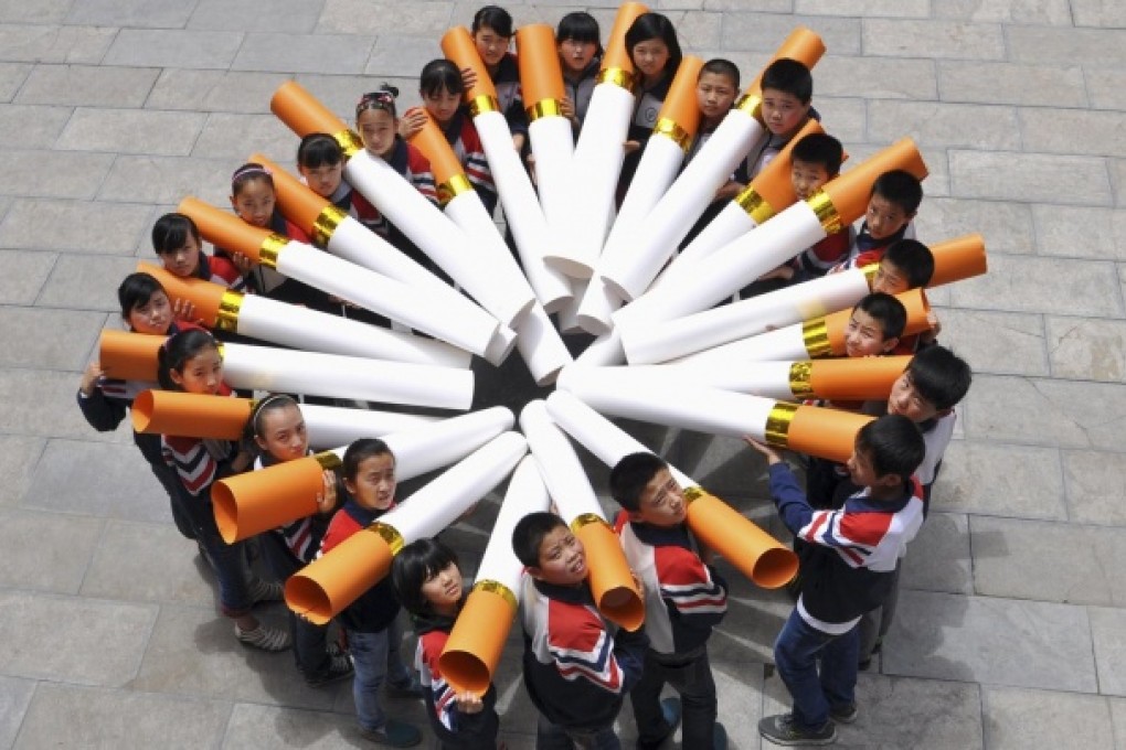 Pupils pose with model cigarettes during a campaign for World No Tobacco Day at a school in Handan, Hebei province. Photo: Reuters