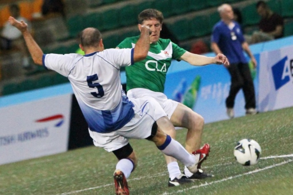 Peter Beardsley (right) tries to evade the tackle of the Chairman's Select's Ariel Navarro during the Sevens. Photo: Edward Wong