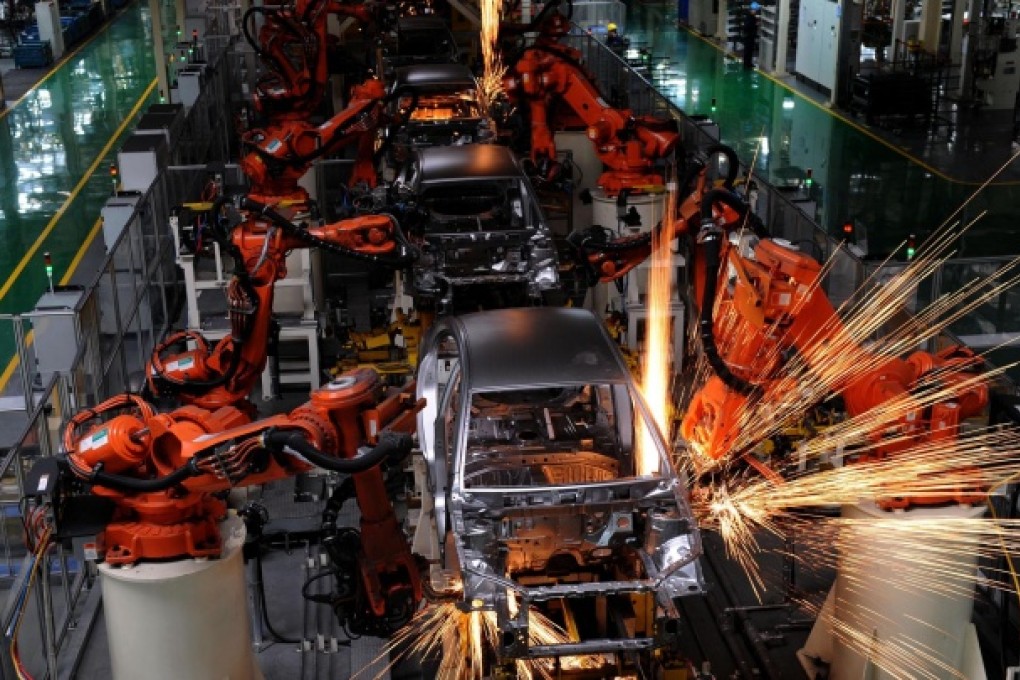 Robotic arms weld cars in a factory in Zhejiang province.
