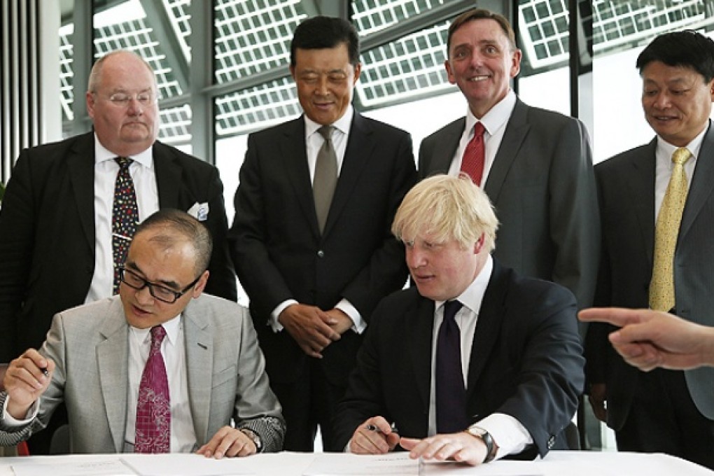 London Mayor Boris Johnson and Advanced Business Parks Chairman Xu Weiping sign documents at City Hall in London. Photo: Reuters