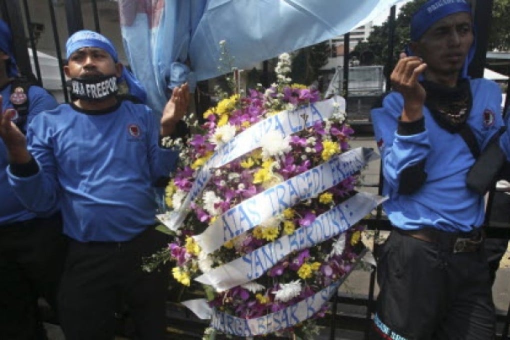 Members of Indonesian Workers Union (SPSI) pray during a solidarity rally for the victims of the collapsed mine at a Freeport Indonesia's mining area in Papua province, outside the Ministry of Energy And Natural Resources in Jakarta, Indonesia. Photo: AP