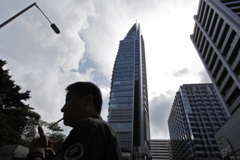 A man smokes a cigarette against Hong Kong's shopping district. Photo: AP