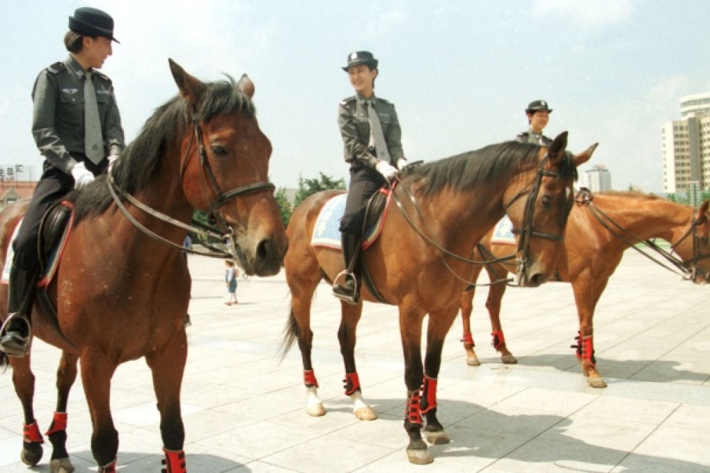 Policewomen patrol on horseback at a park in Dalian on June 15, 2000. Photo: AP