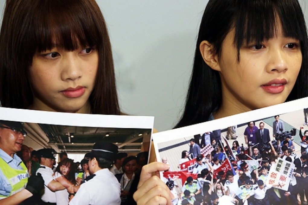 Willis Ho (left) and Siu Ming of the Hong Kong Federation of Students at the IPCC office in Wan Chai on Thursday show photos of police handling their May 19 demonstration. Photo: Sam Tsang