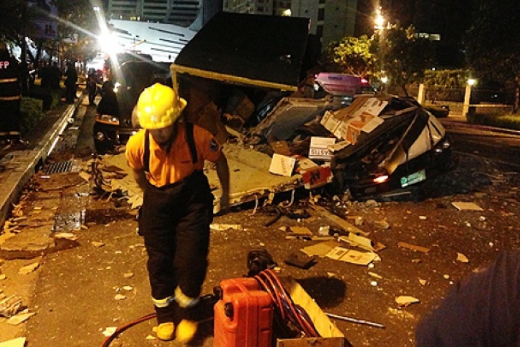 A rescue worker stands in front of a van damaged by debris from an explosion at a residential condominium in Taguig City, east of Manila, the Philippines, on Friday. Photo: EPA