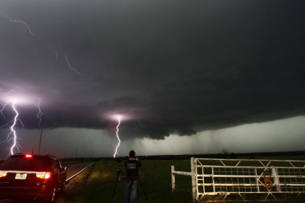 Lightning strikes near storm chasers during a thunderstorm triggered by a tornado in Cushing, Oklahoma. Photo: Reuters