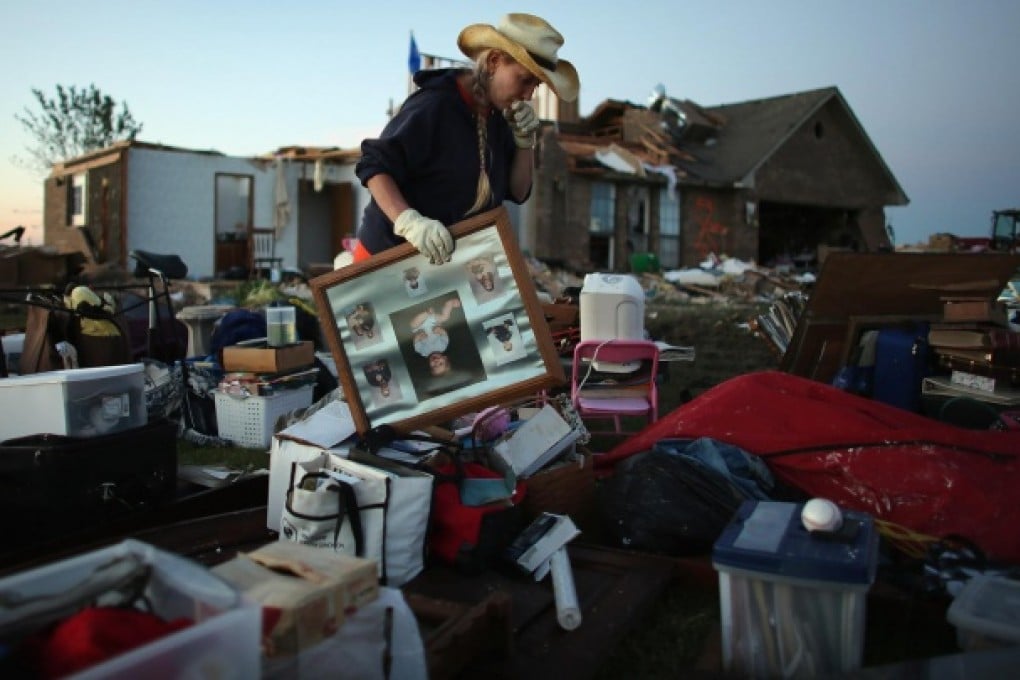 Charlene Wilford helps retrieve items from a home damaged by the tornado that hit El Reno, Oklahoma. Photo: AFP