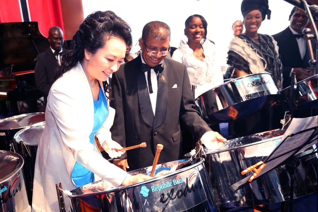 Peng Liyuan, wife of Chinese President Xi Jinping, plays a steel drum after watching an artistic show by local performers at the national performing arts centre in Port of Spain, Trinidad. Photo: Xinhua