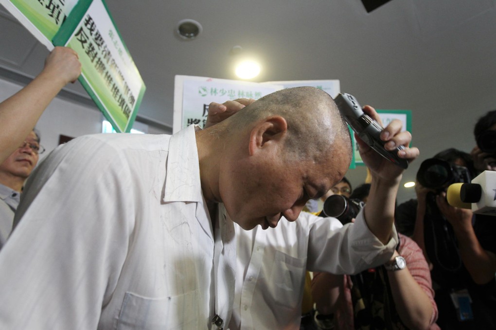 Cheung Chi-tung from Tseung Kwan O cuts off his hair outside Legco. Photo: Edward Wong