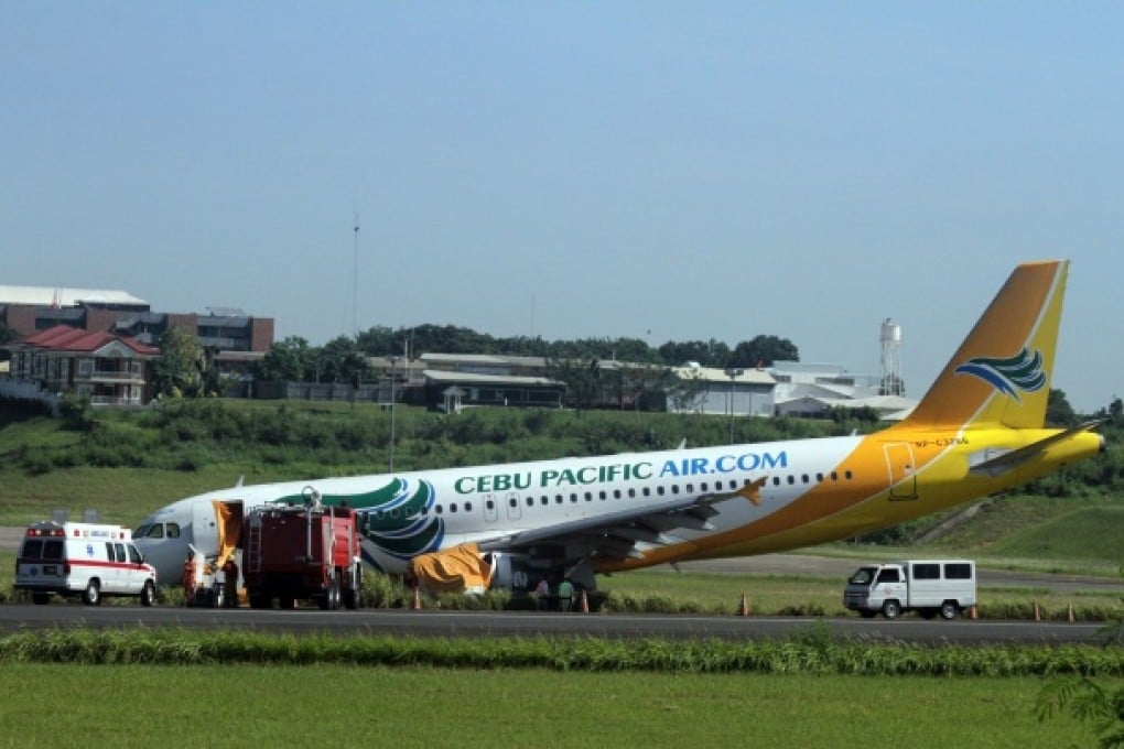 A Cebu Pacific Airbus A320 plane sits on the grassy part of the runway at the international airport in Davao, after it overshot the runway. Photo: AFP