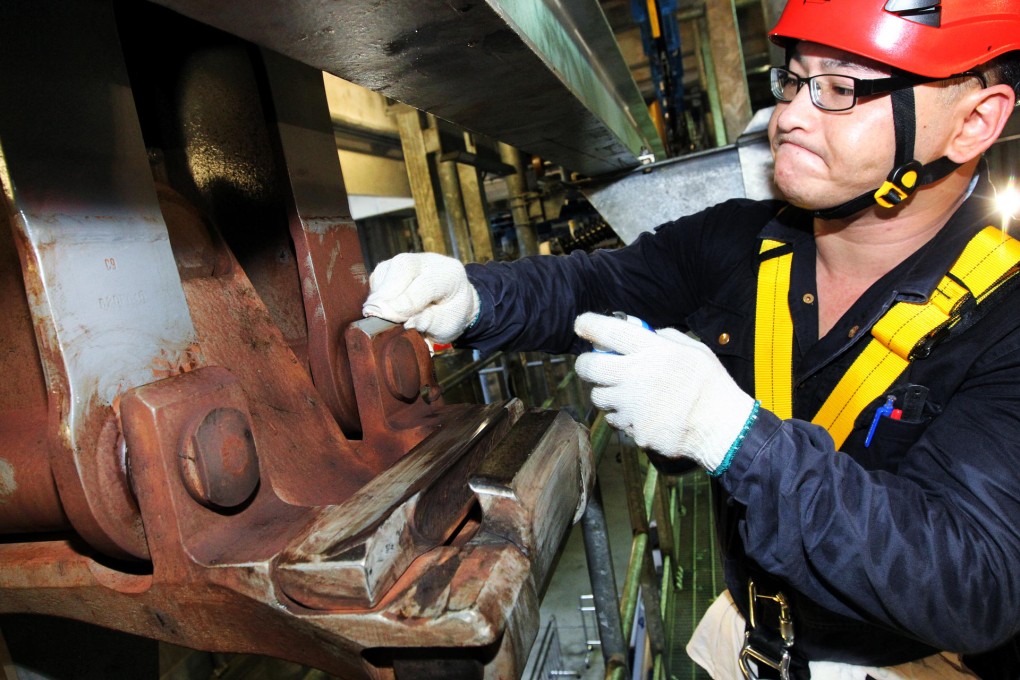 Fok Chun-wai, a technician at Ngong Ping 360, wipes brown stains on components that the gondola lift operator says should not be confused with rust. Photo: May Tse