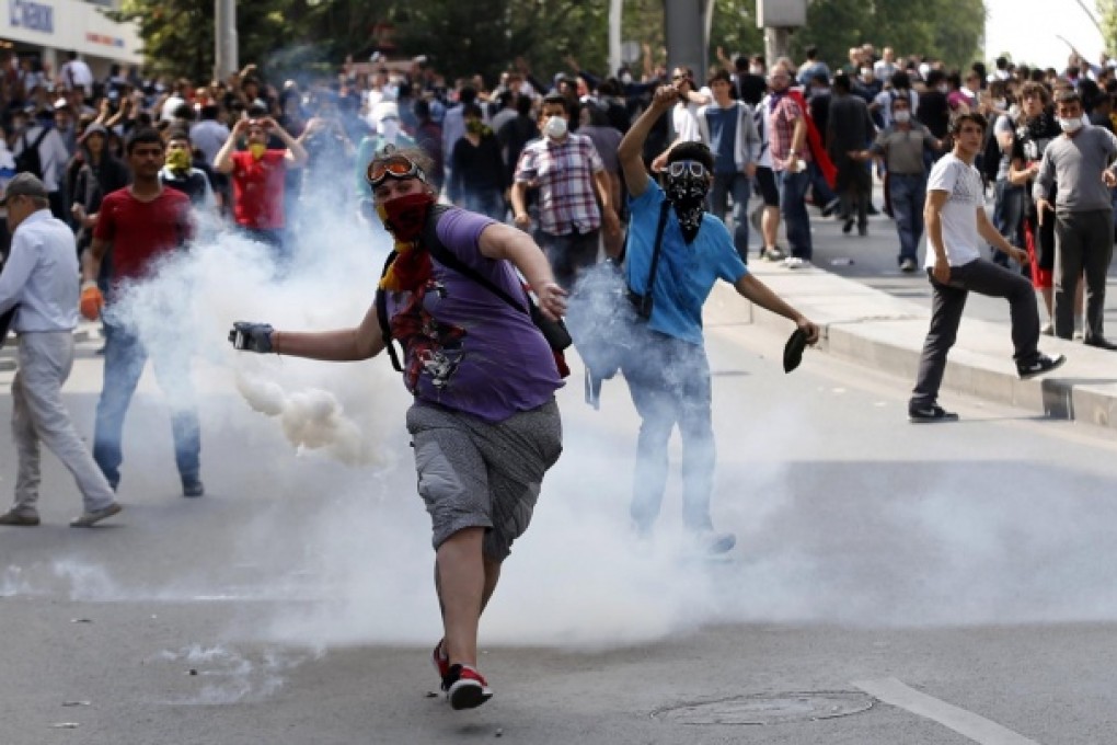 A protester throws a gas canister back towards riot police during a demonstration yesterday in the Turkish capital. Photo: Reuters