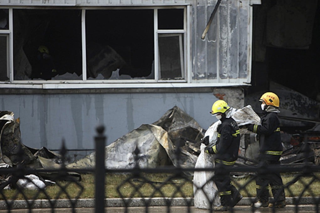 Firefighters outside the poultry slaughterhouse. Photo: Reuters