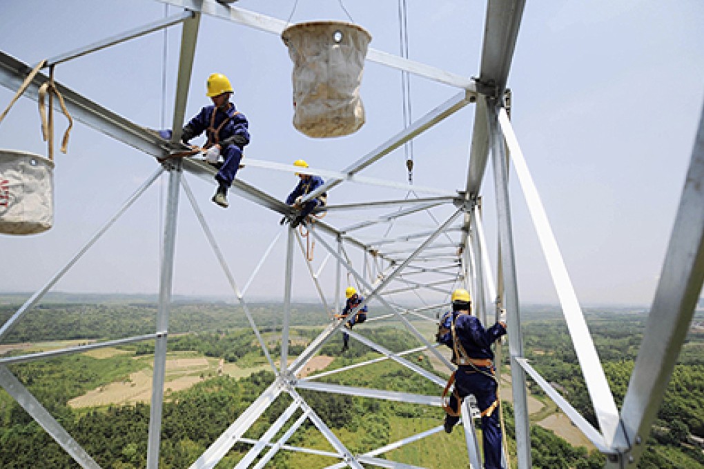 Workers install a high voltage electricity pylon in Xuancheng, Anhui province. Photo: Reuters