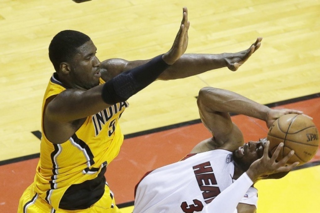 The Heat's Dwyane Wade shoots under pressure from the Pacers' Roy Hibbert during the Eastern Conference finals play-off decider. Photo: AP