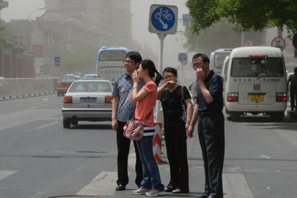 Pedestrians try to protect themselves against choking traffic fumes in Beijing. Photo: AFP