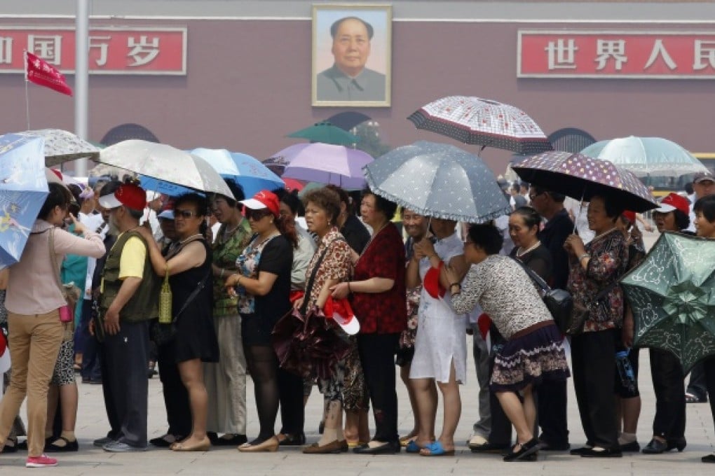 Tourists holding umbrellas visit Tiananmen Square in Beijing. Photo: Reuters