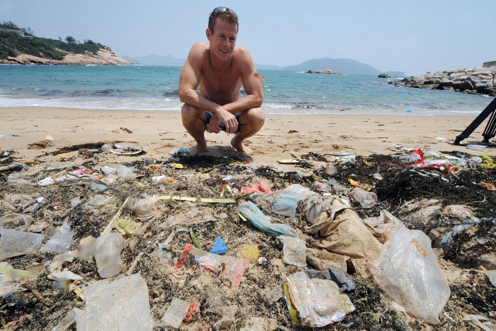 Life's a beach? Ocean Recovery Alliance founder Doug Woodring crouches before a mound of plastic debris on one of Hong Kong's southern beaches. Photo: AFP