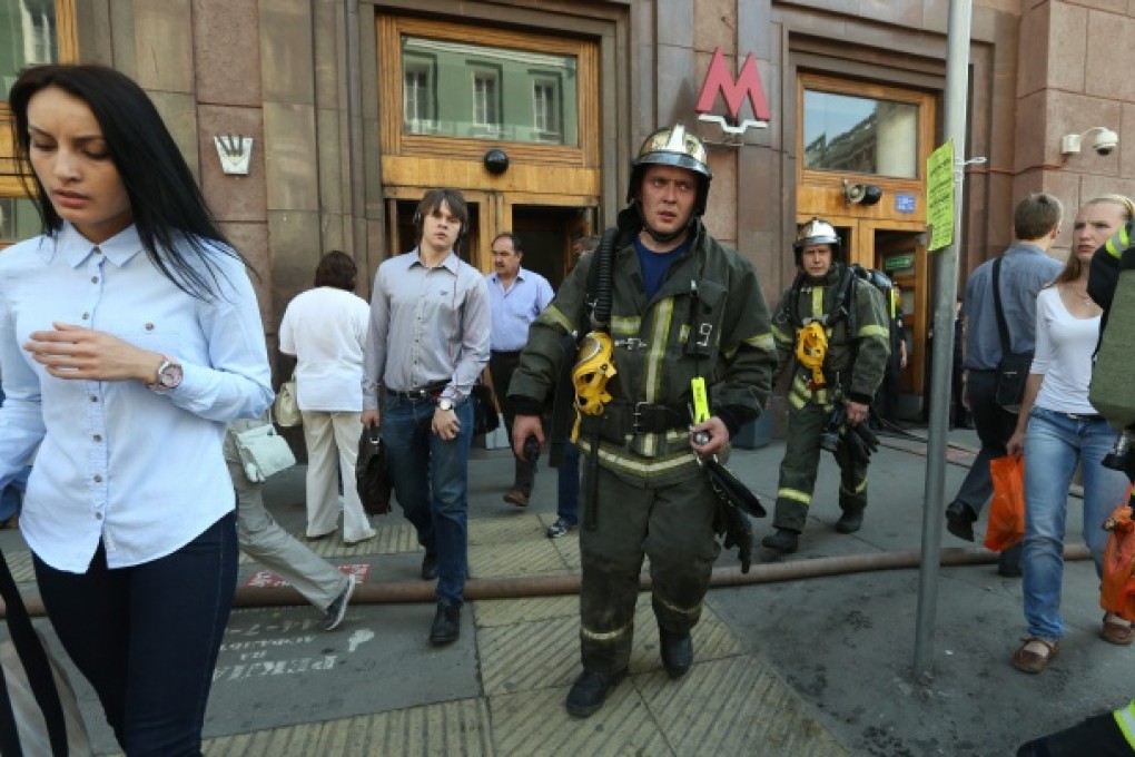 Passengers and fire fighters leave the metro station Okhotny Riad in the center of Moscow. Photo: EPA