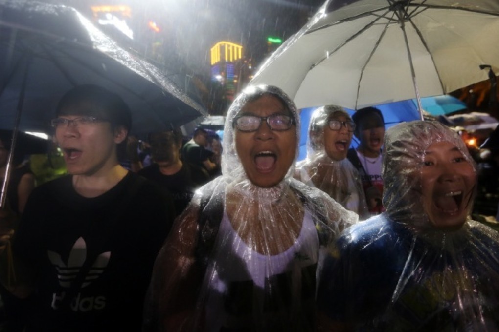 Weather could not dampen the spirits of the thousands who gathered last night for the vigil at Victoria Park to mark the 24th anniversary of June 4, holding lit candles against the torrential rainfall. Photo: Sam Tsang
