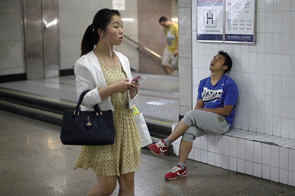 A woman walks past an entrance to a subway station in Beijing. Photo: Reuters
