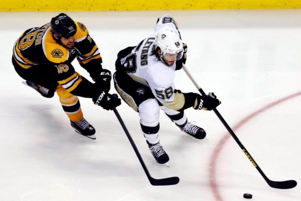 Penguins' Kris Letang is in control of the puck as Bruins' Nathan Horton looms behind him in game three of their Eastern Conference finals series. Photo: AFP