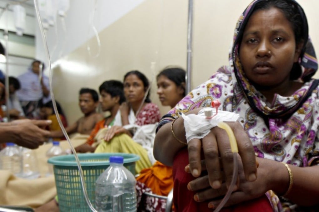 Garment factory workers rest on the floor as they receive intravenous drips after falling sick, on the outskirts of Dhaka. Photo: AFP